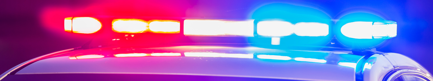 Close-up of flashing red and blue police car lights at night, illustrating the urgent atmosphere often encountered by a corporate law office offering litigation support.