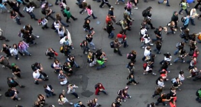 Aerial view of a large crowd of people walking in various directions on a city street, reflecting the dynamic energy found among lawyers in Chicago navigating cases and providing litigation support.