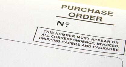 Close-up of a purchase order form with a blank field for the order number and a note instructing use of this number on all related documents and packages in a corporate law office.
