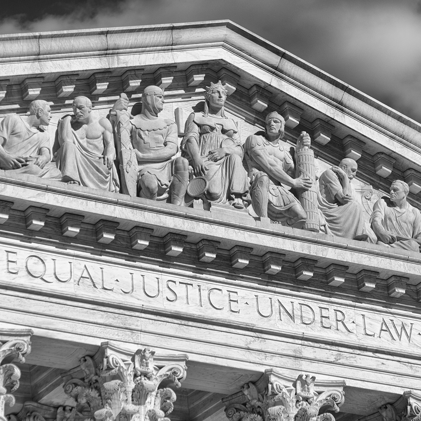 Stone sculptures of figures sit atop the pediment of a neoclassical building with the inscription "EQUAL JUSTICE UNDER LAW" carved below—an inspiring sight for Chicago lawyers and law offices dedicated to justice.