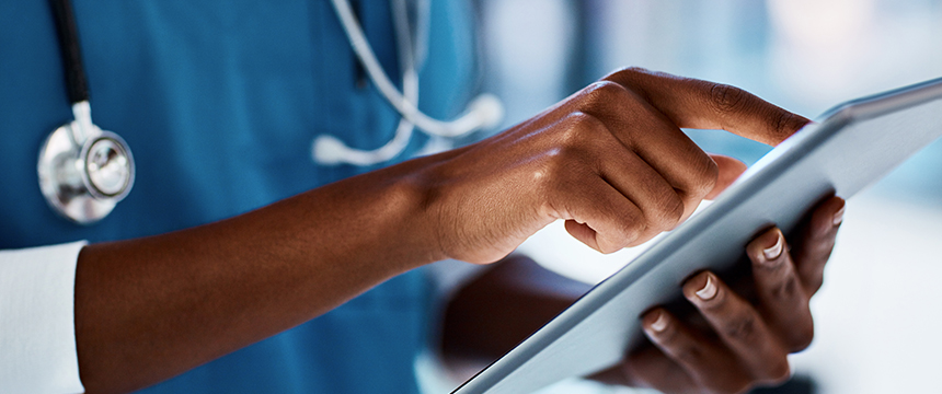 A healthcare professional in scrubs uses a digital tablet, with a stethoscope visible around their neck, accessing litigation support tools to securely manage patient cases.