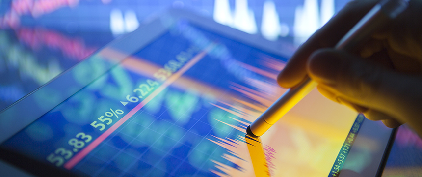 A hand uses a stylus on a tablet displaying colorful financial graphs and stock prices, set against a blurred background—an essential tool for lawyers in Chicago navigating complex corporate law office transactions.