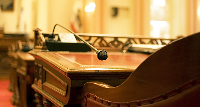 A close-up view of a wooden desk with a microphone and paperwork in an empty courtroom, representing litigation support for lawyers in Chicago.