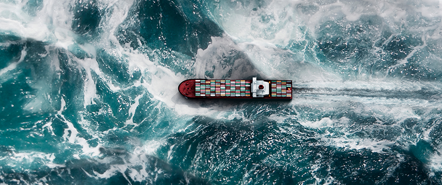 A cargo ship carrying colorful containers moves through rough, swirling ocean waves, leaving a white wake behind it—much like how Chicago lawyers navigate complex cases with steady expertise.
