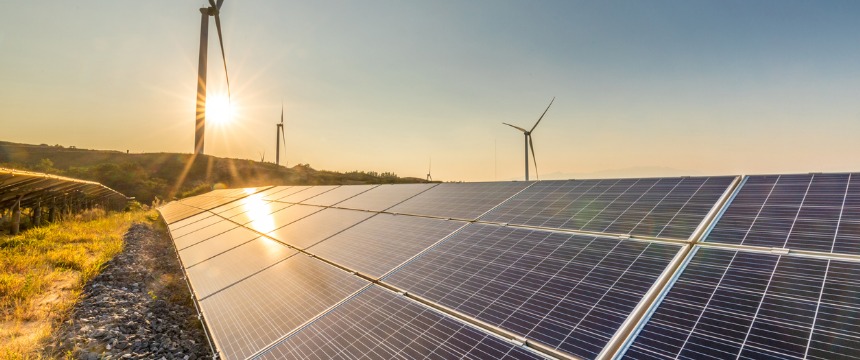 Solar panels and wind turbines in a rural landscape capture renewable energy under a clear sky at sunset, symbolizing innovation and sustainability valued by any forward-thinking corporate law office.