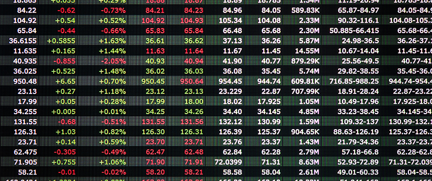 A digital display showing stock market data with numbers in green and red indicating price changes, trading volume, and percentage changes in a corporate law office.