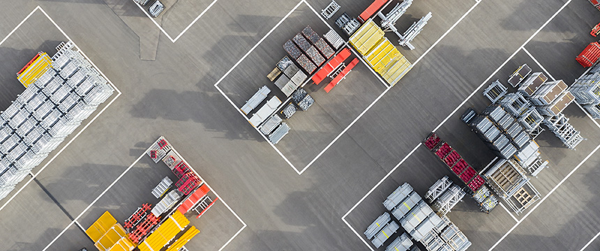 Aerial view of an industrial storage yard with neatly organized stacks of materials and equipment, separated by white lines on a paved surface—ideal for chicago lawyers specializing in litigation support and complex case logistics.