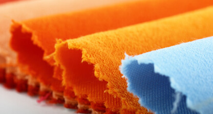 Close-up of several fabric swatches in orange and blue tones with pinked, zigzag edges, arranged in overlapping rows—an image often seen in corporate law offices or among Chicago lawyers specializing in intellectual property law.