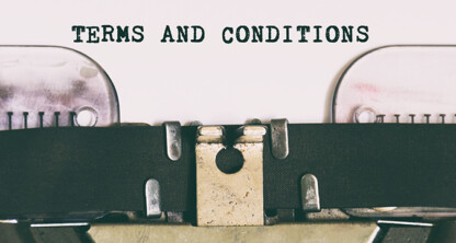 A close-up of a typewriter typing the words "TERMS AND CONDITIONS" on white paper in a corporate law office.