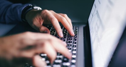 Close-up of hands typing on a laptop keyboard, with a blurred screen in the background—ideal for lawyers in Chicago or law offices handling sensitive intellectual property law cases.