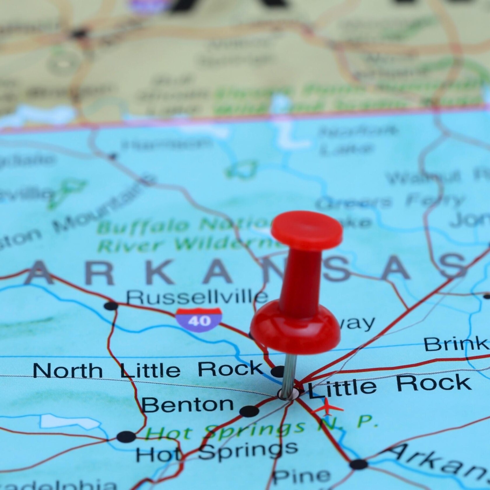 A red pushpin marks Little Rock, Arkansas, on a map. Nearby cities and highways, including Benton and Interstate 40, are visible—much like how a corporate law office might pinpoint key locations for litigation support.