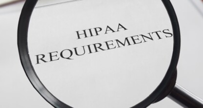 A magnifying glass focuses on a document titled "HIPAA REQUIREMENTS," with a blurred medical symbol and a pen visible in the background, evoking the precision of corporate law office practices among top Chicago lawyers.