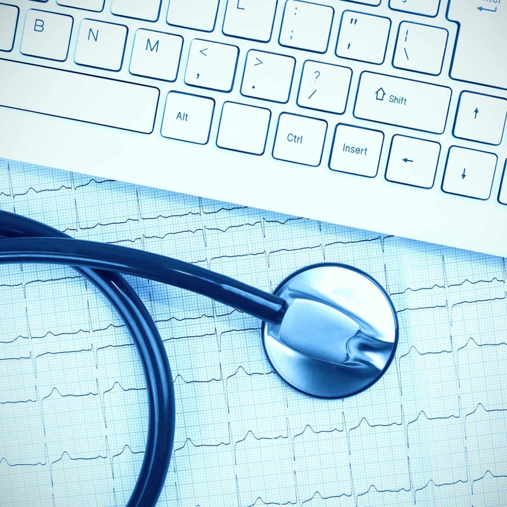 A stethoscope rests on an electrocardiogram printout next to a white computer keyboard, reflecting the meticulous approach of lawyers in Chicago who provide litigation support in medical cases.