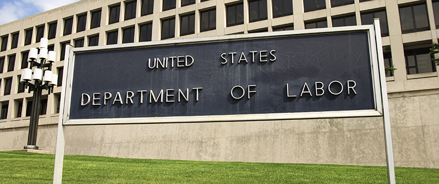 A sign reading "United States Department of Labor" stands in front of a large office building with multiple windows and a green lawn, reminiscent of the professional settings found at top law offices or a bustling corporate law office.