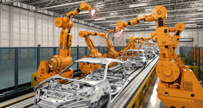 Robotic arms assemble car bodies on an automated production line inside a large, modern factory, showcasing technology that may require litigation support or protection under intellectual property law.