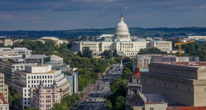 Aerial view of the United States Capitol building in Washington, D.C., with surrounding city streets, trees, and nearby buildings visible—much like the bustling scene outside a major corporate law office or litigation support center.