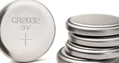 A close-up of several silver CR2032 3V coin cell batteries, one upright showing the label and others stacked horizontally—perfect for presentations by lawyers in Chicago on product standards.