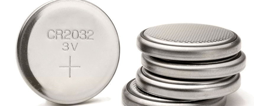 A close-up of several silver CR2032 3V coin cell batteries, one upright showing the label and others stacked horizontally—perfect for presentations by lawyers in Chicago on product standards.