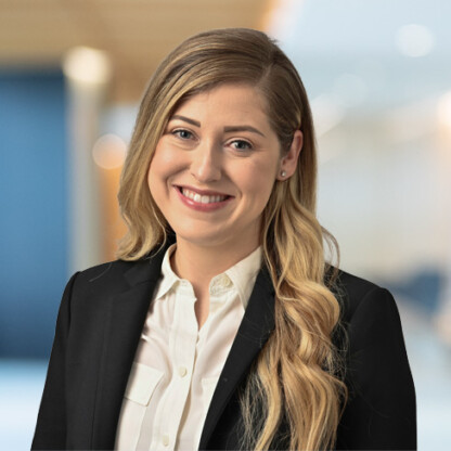 Woman with long blonde hair wearing a black blazer and white shirt, smiling at the camera in a corporate law office, showcasing litigation support professionals and lawyers in Chicago.
