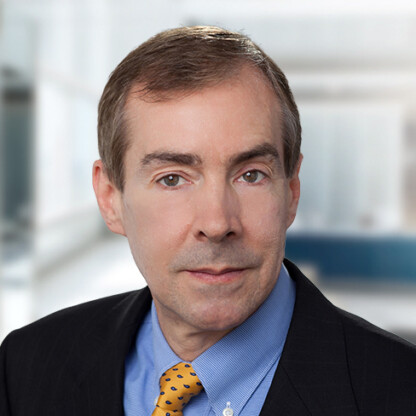 A middle-aged man in a suit, blue shirt, and yellow polka dot tie poses confidently in a bright office setting, reflecting the professionalism of leading law offices and Chicago lawyers.