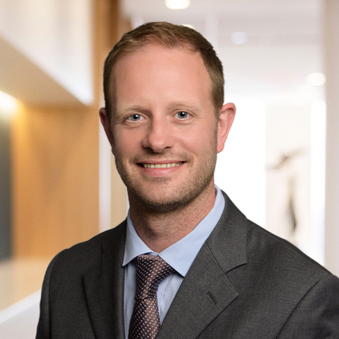 A man in a business suit and tie is smiling in a well-lit, modern office setting, representing experienced chicago lawyers offering professional litigation support.