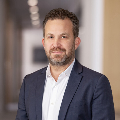 A man in a suit stands confidently, embodying the professionalism found at law offices specializing in intellectual property law.