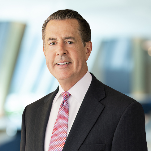 A man in a dark suit, white shirt, and red patterned tie stands in front of a blurred office background, representing distinguished lawyers in Chicago.