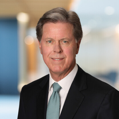 A middle-aged man in a suit and tie poses for a professional headshot against a blurred office background, reflecting the expertise and professionalism found in Chicago lawyers and top law offices.