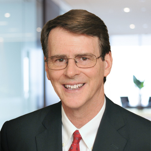 A man wearing glasses, a dark suit, white shirt, and red tie smiles in an office setting with glass walls—reflecting the professionalism of top lawyers in Chicago.