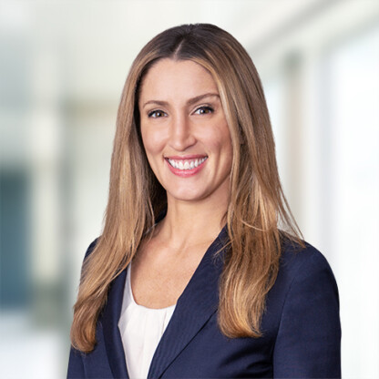 Woman with long straight hair wearing a dark blazer and white top, smiling in a bright, professional corporate law office setting with a blurred background—perfectly capturing the atmosphere of leading Chicago lawyers and modern law offices.