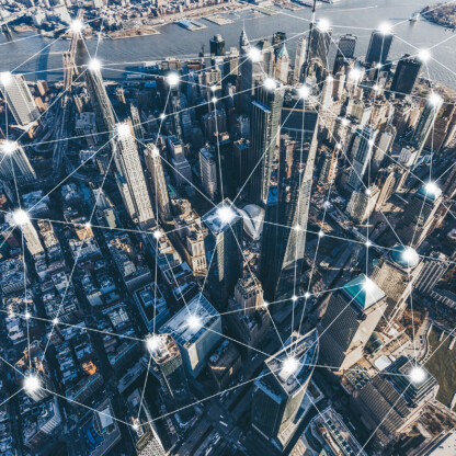 Aerial view of a city skyline with digital network lines and nodes superimposed, symbolizing urban connectivity, communication technology, and the collaborative reach of law offices and litigation support in Chicago.