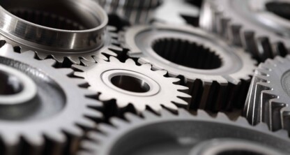 Close-up of several interlocking metal gears and cogs, symbolizing the precision and teamwork essential for Chicago lawyers specializing in intellectual property law.