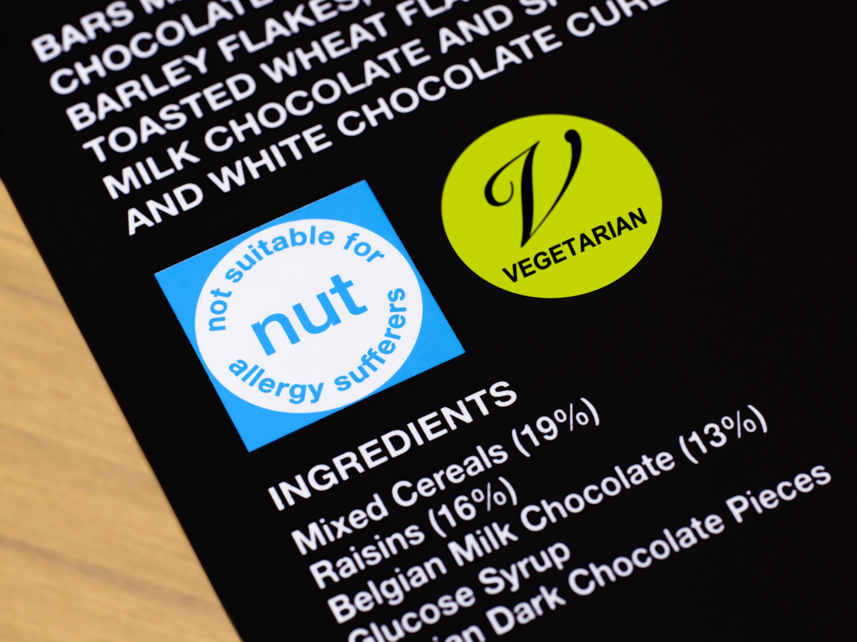 Food label with a blue "not suitable for nut allergy sufferers" symbol, a green "vegetarian" symbol, and a partial list of ingredients—similar attention to detail you'd expect from top intellectual property law experts.