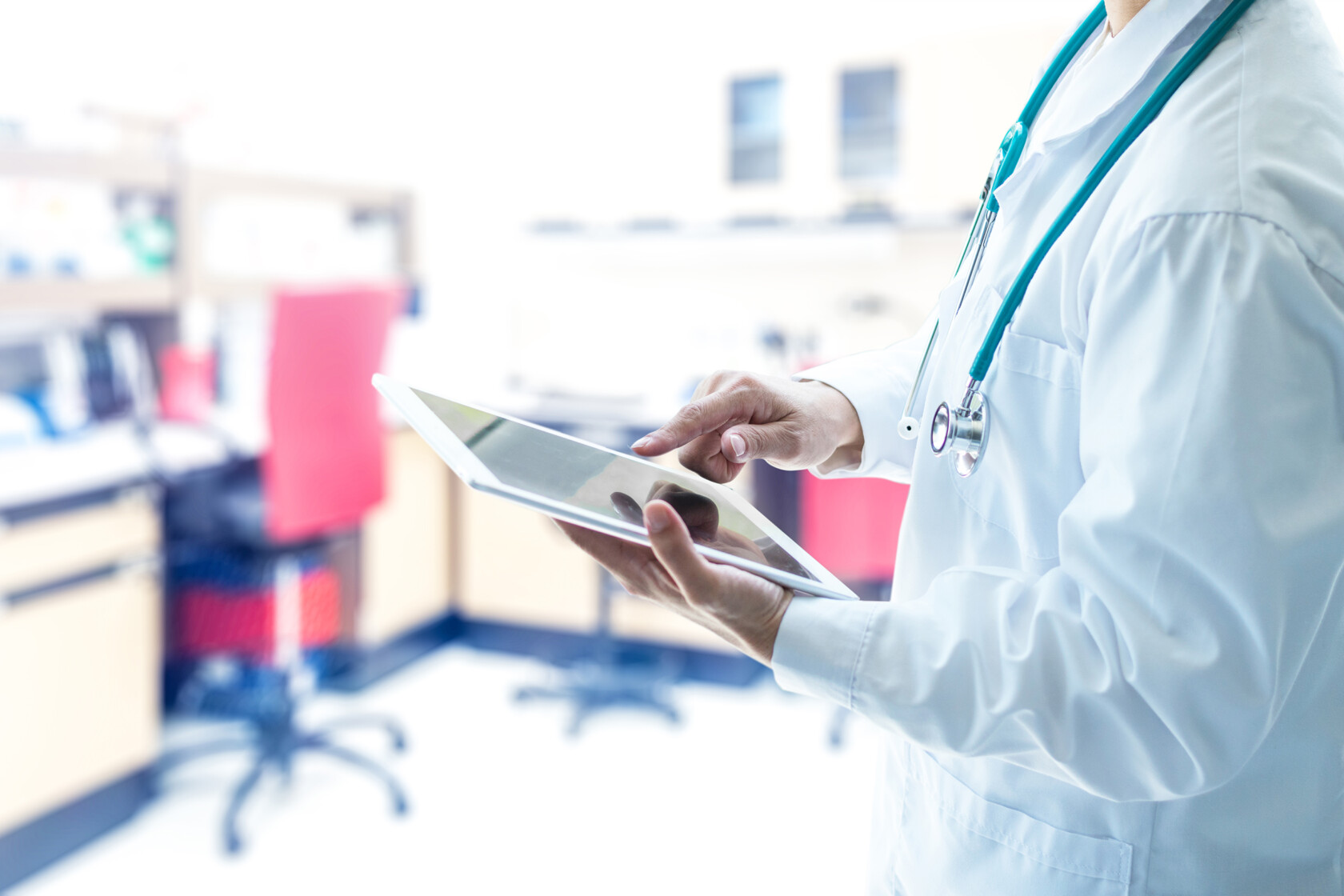 A medical professional in a white coat uses a tablet in a bright, modern clinic, consulting with chicago lawyers on intellectual property law.