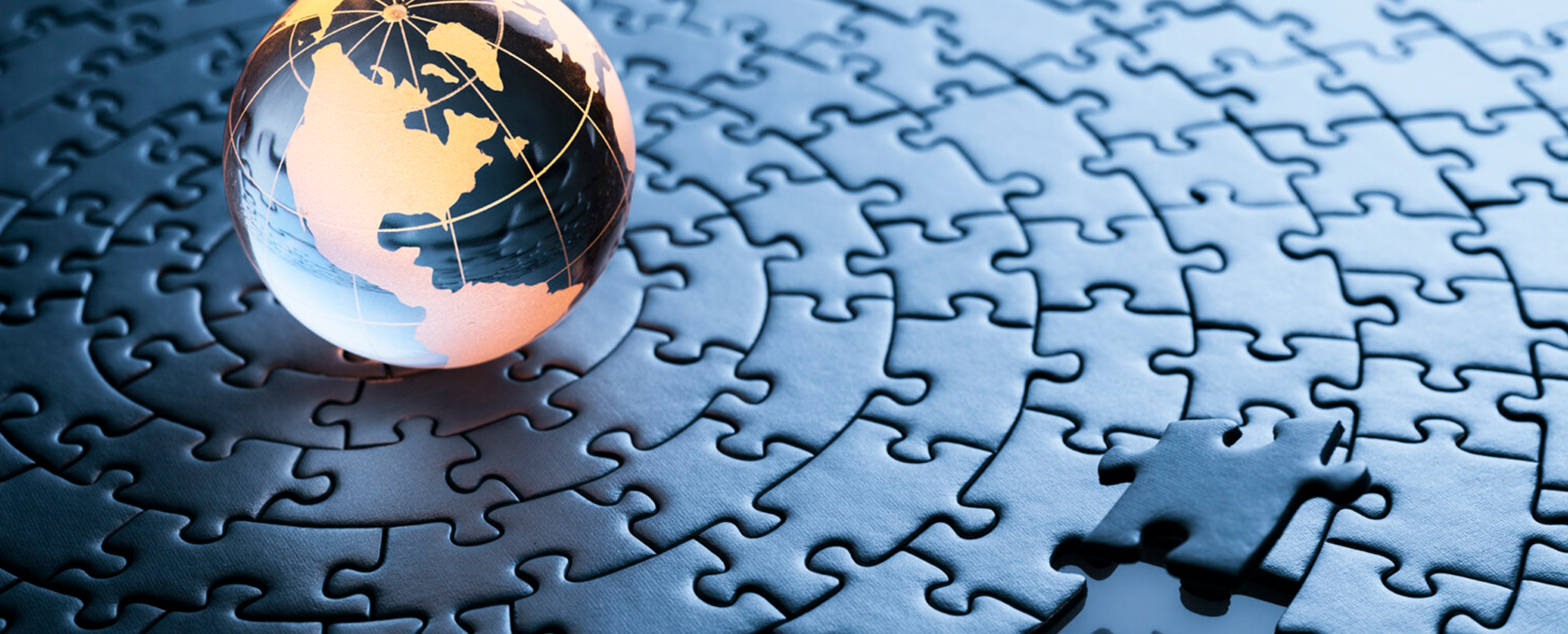A glass globe rests on a completed circular jigsaw puzzle with one piece missing in the foreground, evoking the intricate problem-solving and precision of a top corporate law office.