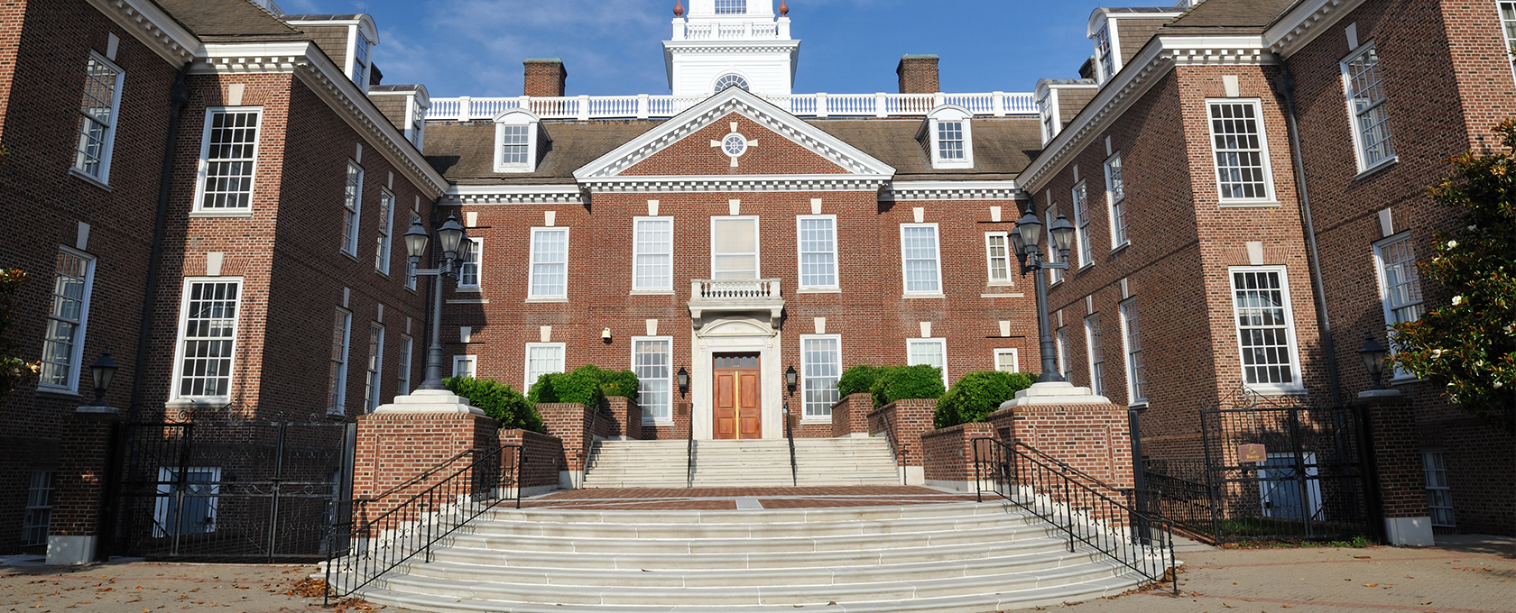 A large brick government building with white trim, tall windows, and a central entrance with a staircase leading up to double wooden doors—typical of where leading law offices and lawyers in Chicago practice intellectual property law.