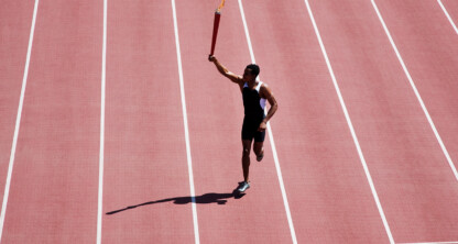 Athlete running on a red track holding a torch aloft, casting a shadow, with empty lanes on either side—symbolizing the determination found in top lawyers in Chicago.