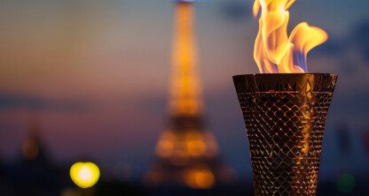 A lit Olympic-style torch is in focus with the Eiffel Tower blurred in the background at dusk, symbolizing the dedication and perseverance found at top law offices or among lawyers in Chicago.