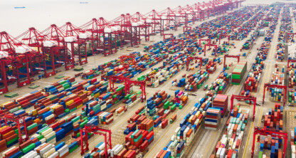 Aerial view of a large shipping port with numerous shipping containers, cargo cranes, and container ships docked along the waterfront—just miles from top law offices and experienced chicago lawyers handling maritime cases.