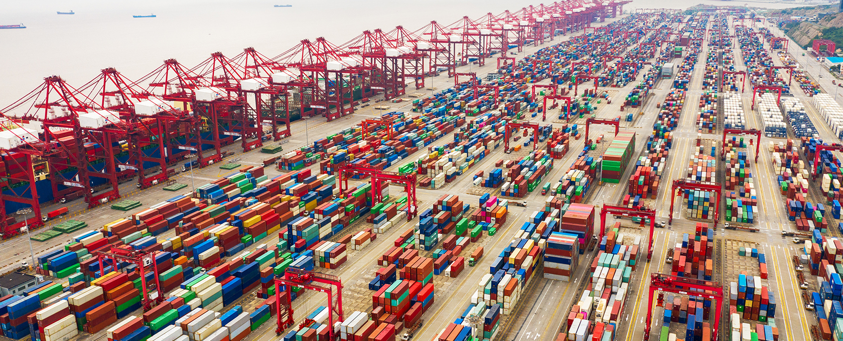 Aerial view of a large shipping port with numerous shipping containers, cargo cranes, and container ships docked along the waterfront—just miles from top law offices and experienced chicago lawyers handling maritime cases.