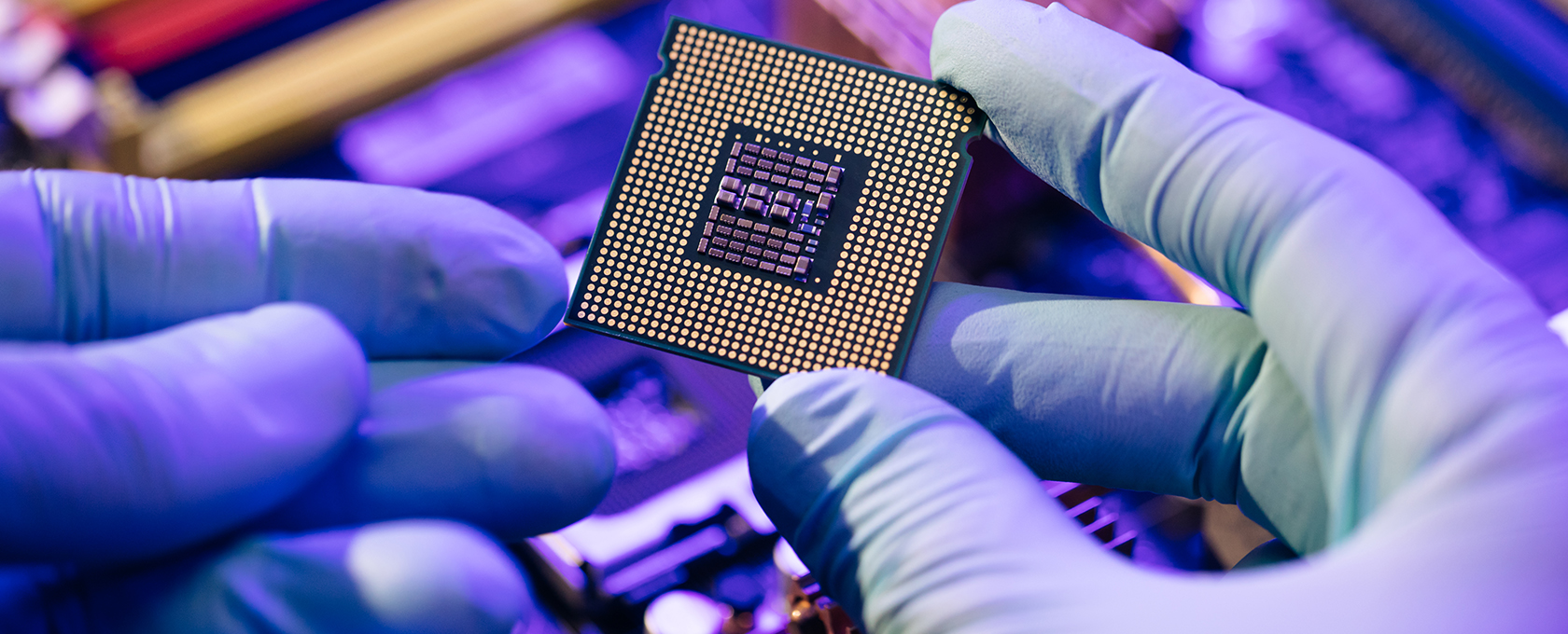 A person wearing blue gloves holds a computer processor chip above a motherboard, highlighting its gold contacts and detailed circuitry—reflecting the precision found in litigation support for lawyers in Chicago.