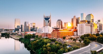 Downtown Nashville skyline at sunset with the AT&T building, various skyscrapers, and the Cumberland River in the foreground—an inspiring view for any corporate law office seeking dynamic surroundings.