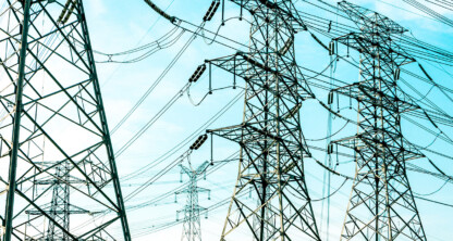 High-voltage electricity transmission towers and wires set against a blue sky, highlighting the infrastructure often at the center of litigation support for Chicago lawyers specializing in intellectual property law.