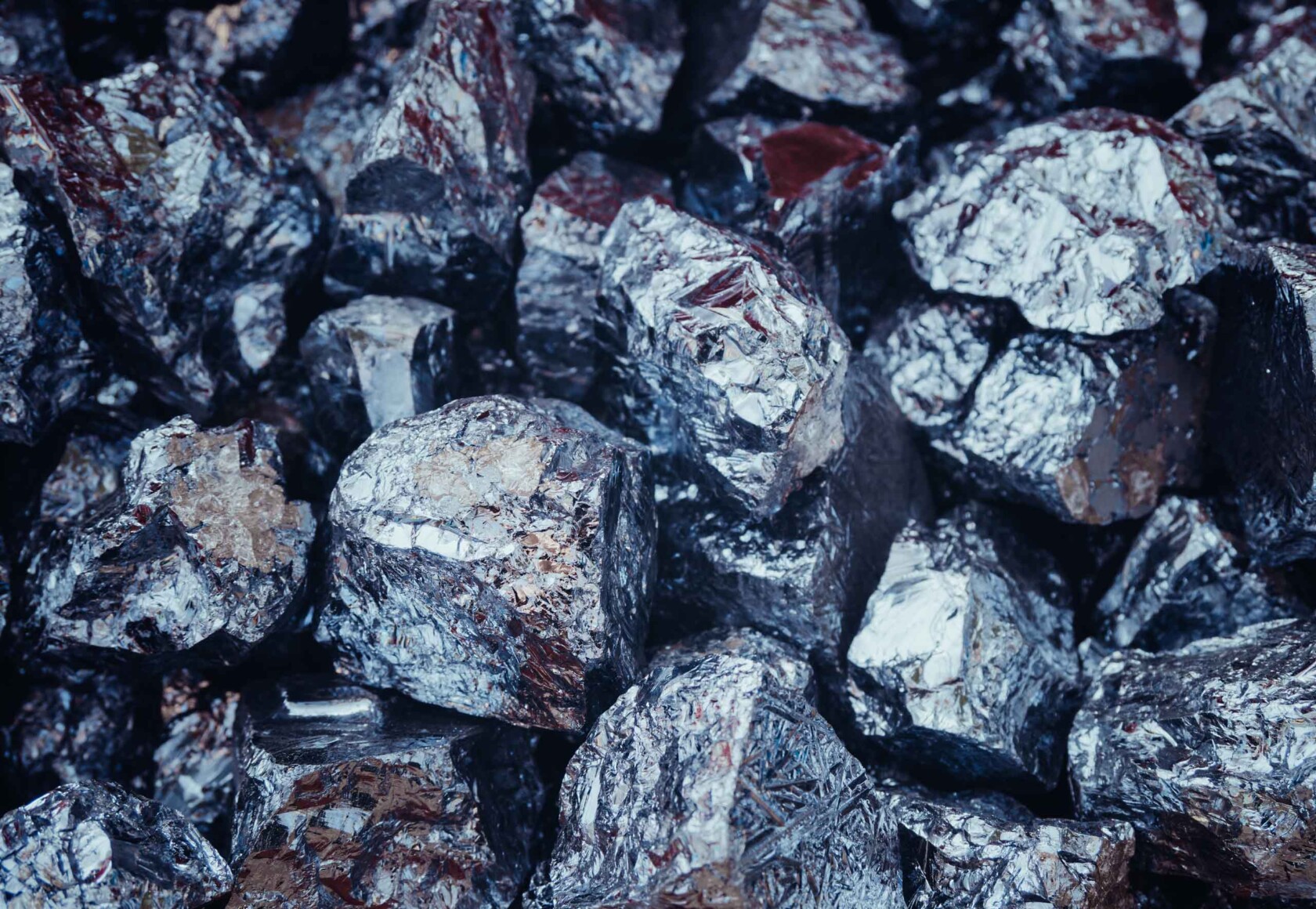 A pile of rough, shiny metallic rocks with a silvery appearance.