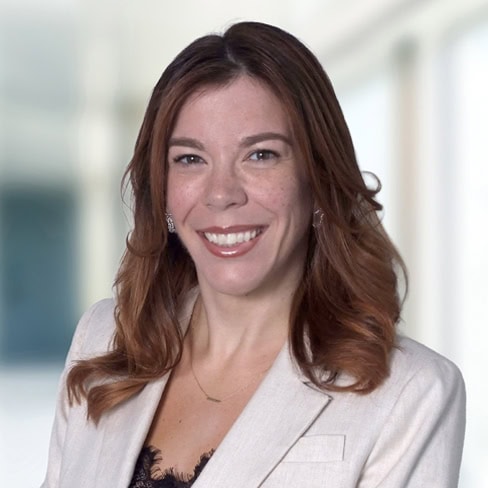Professional woman with red hair in business attire at Foley & Lardner LLP law firm office.